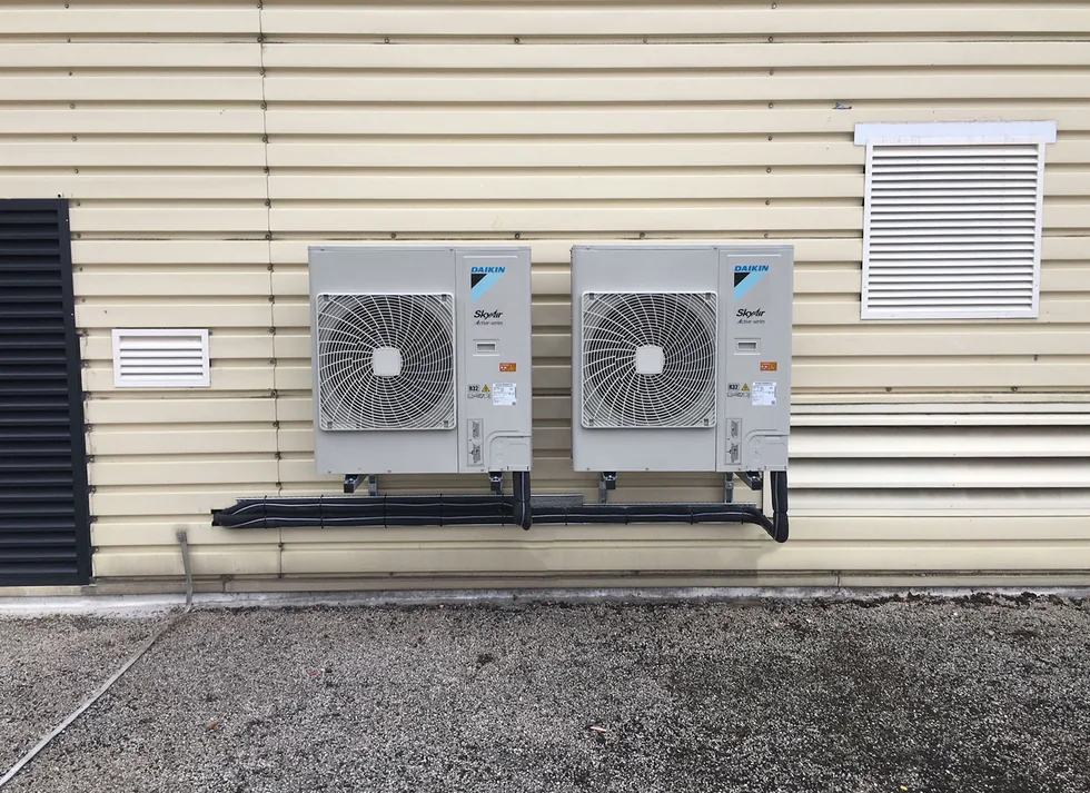 Two outdoor air conditioning units with neatly routed pipework.